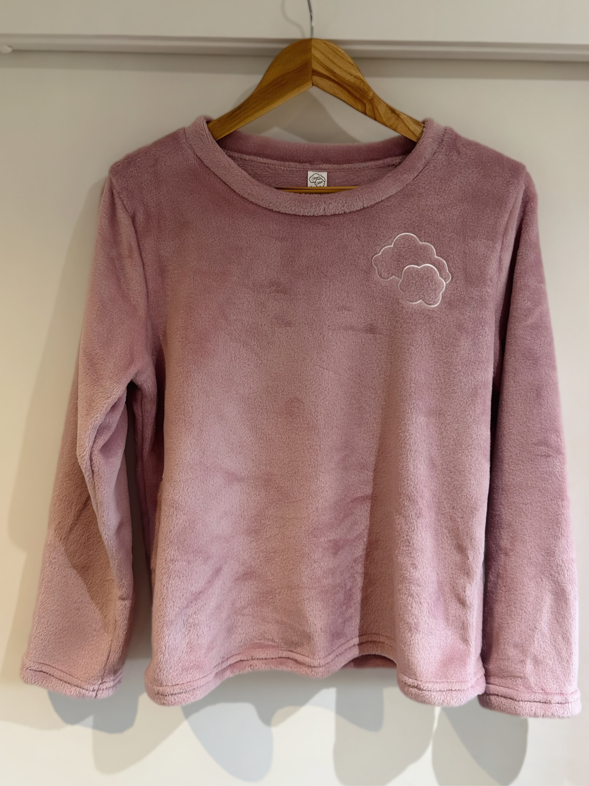 Touch of Heaven long-sleeve pajama top on hanger – soft pink with embroidered cloud detail.
